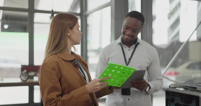 A diverse team of startup professionals collaborates on a 3D printing project in a modern workspace. Highlighting innovation, teamwork, and the prototyping process in a creative tech environment.
