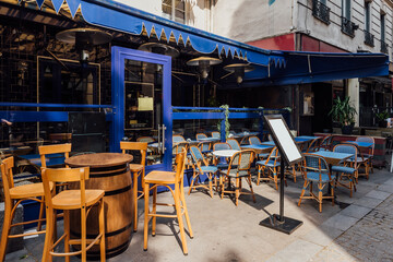 Fototapeta premium Cozy street with tables of cafe in Paris, France. Architecture and landmark of Paris. Cozy Paris cityscape.