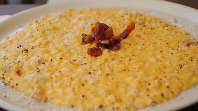 Risotto carbonara texture, delicious twist on the famous first course made with egg yolks, pecorino, and guanciale. High quality 4k footage