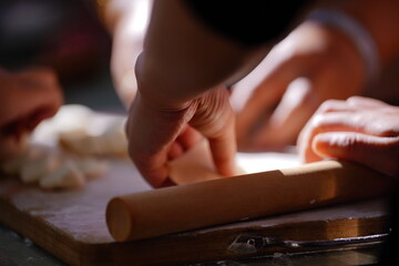 Obraz premium A young home cook meticulously prepares Chinese dumplings on a worn