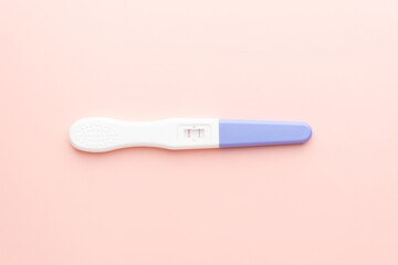 Positive urine pregnancy test on pink background. Pregnancy test kit measure hCG levels in urine.