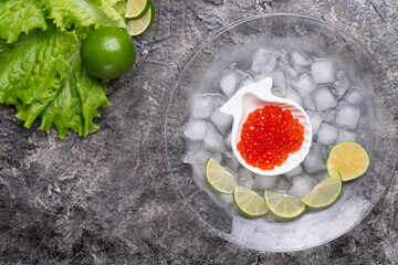  fresh red  salmon caviar with lime around ice. close up.  Protein delicacy  healthy food