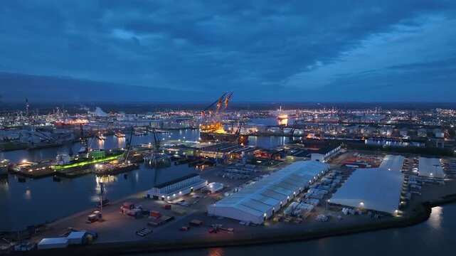 Rotterdam, Netherlands. Drone flight over industrial area with cargo ports, containers and a semi-submersible ship, heavy lifting crane. Machines designed for work at sea
