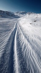 A serene and untouched snowy mountain landscape with a winding trail