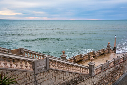 Historic seaside balustrade of Sitges overlooking the Mediterranean Sea under dramatic overcast sky