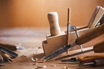 Woodworking tools on wooden workbench in carpentry workshop. Joinery and craft carving tools for wood processing. © juliasudnitskaya