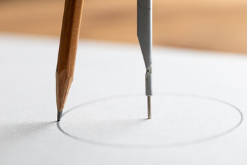 Closeup vintage drawing compass on wooden table. Drafting tool for geometry education and planning design.