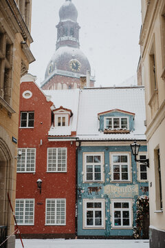 Snowy Old Town Street in Riga, Latvia with Riga Cathedral Dome in Background