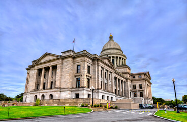 Obraz premium Arkansas State Capitol building in Little Rock. Historic Neoclassical government architecture features a limestone facade and dome under a blue sky with clouds
