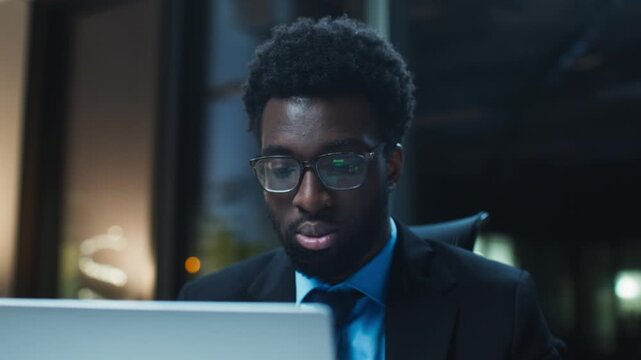 Close up male business professional looking at computer monitor. Checking written content and verifying accuracy while working late. Focused face reflecting concentration to detail during task.