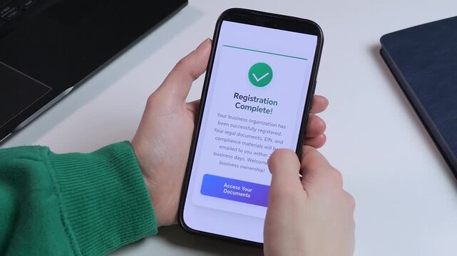 Close-up of a smartphone screen showing a successful business registration. Perfect for fintech, legal services, and startup-themed content. High-quality UI design with a green checkmark symbolizing