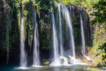 Obraz premium Alexander the Great Waterfall. Caves under the waterfall. The water is pouring from a great height. The old karst channel of the Dudensky upper waterfall is decorated in the form of caves.