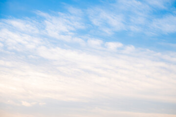 Fototapeta premium Beautiful blue sky background with soft white clouds and natural morning sunlight. Bright heaven landscape for summer seasonal design, weather forecast, and spiritual concept