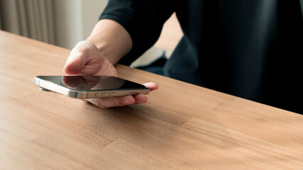 リラックスする男性の手元 スマートフォンとコーヒー ライフスタイル / Man using smartphone on wooden table, relaxed lifestyle