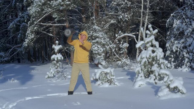 Man training with kettlebell outdoors in snowy winter forest, Functional strength workout in cold nature environment improving power and endurance