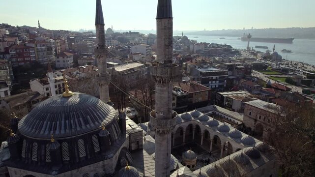 Aerial footage of Yeni Valide Mosque in &Uuml;sk&uuml;dar with the Bosphorus view. Ottoman architecture, domes and minarets blend harmoniously with the sea and urban landscape of Istanbul.
