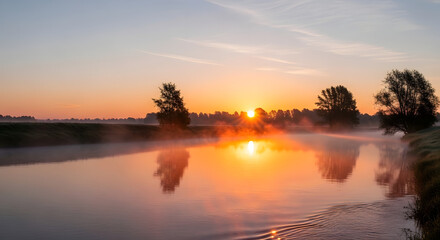Sunrise over calm river with mist rising and trees on horizon