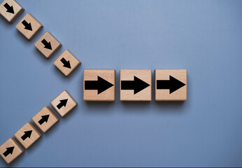 Merge and acquisition business concept with wooden arrow blocks changing direction and aligning into one path. Corporate integration strategy, company partnership deal and organizational growth.