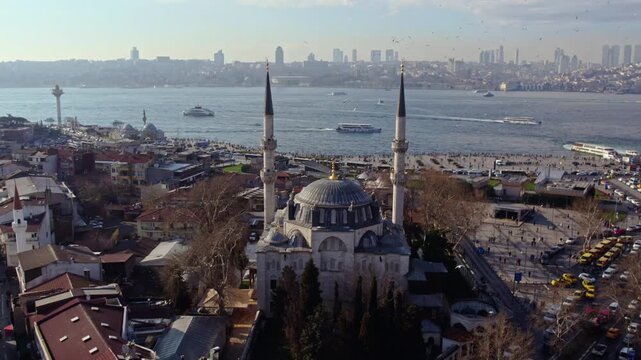 Aerial footage of Yeni Valide Mosque and &Uuml;sk&uuml;dar Ferry Pier in Istanbul. Ferries crossing the Bosphorus, waterfront activity and Ottoman architecture highlight the city&rsquo;s daily life.