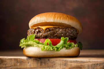 暗い背景に置かれたビーフパティのチーズバーガー