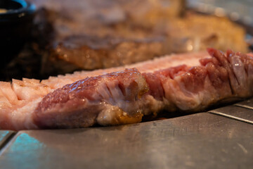 roasting pork belly on charcoal grill in a Korean restaurant