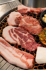 roasting pork belly on charcoal grill in a Korean restaurant