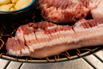 roasting pork belly on charcoal grill in a Korean restaurant