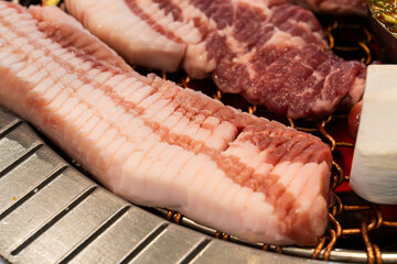 roasting pork belly on charcoal grill in a Korean restaurant