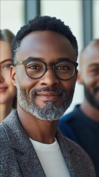 Portrait of a man with glasses, confident facial expression, and professional attire.