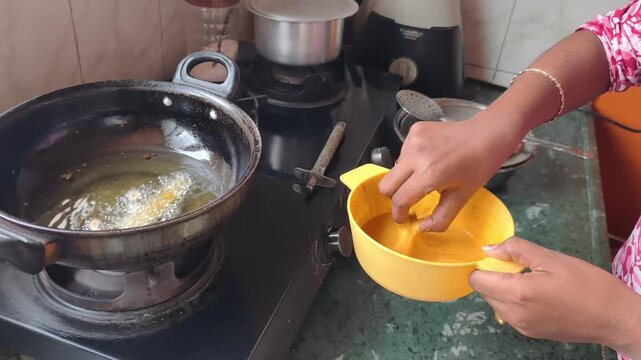 Hands Placing French Fries with chickpea flour coated Pakoda into Hot Kadai, Indian Street Food Frying Process