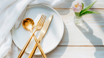 An elegant minimalist table setting with gold flatware and white flowers against a luxurious marble tabletop.