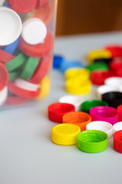 recycling of plastic. colorful lids caps and a canister with collected recyclables