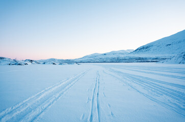 Ski tracks in an open winter landscape in Sweden, above the arctic circle, with dawn light in the sky © Jacob Hall