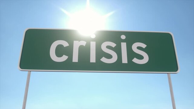 Green Road Sign With Crisis Text Against Bright Sky