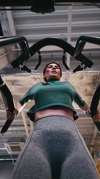 Girl Performing Assisted Dips On Parallel Bars In The Gym With Legs Supported, Viewed From Below, Vertical Video