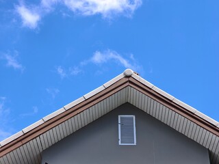 A roof of a house on a clear, bright day with a backdrop of a blue sky © Stock4u2024 