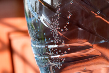 Bubbles rise in sparkling water against a warm sunlight backdrop