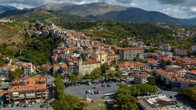 Aerial view of a historic town nestled against a lush hillside. Panorama of Scalea, a town in the province of Cosenza, in Calabria, Southern Italy. The Calabrian Apennines are in the background.