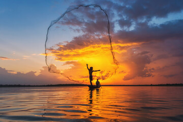 Silhouetted Laguna fisherman casts net at sunset