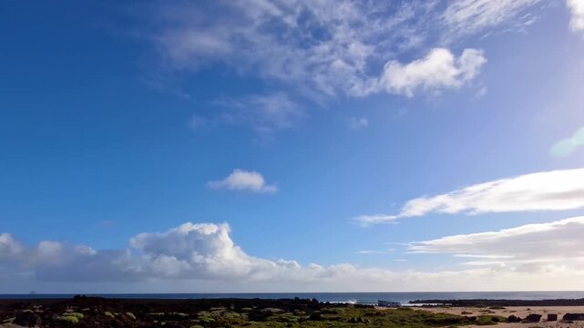 K&uuml;stenstra&szlig;e auf Lanzarote durch eine gr&uuml;n bewachsene felsige vulkanische Landschaft mit Meer und blauem Himmel am Horizont, Freiheit, Abenteuer, Erkundung, reisen, Roadtrip, Kanarische Inseln, Strand