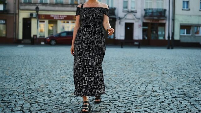 Young Woman In A Light Summer Dress Walks Through The Historical Part Of A European City