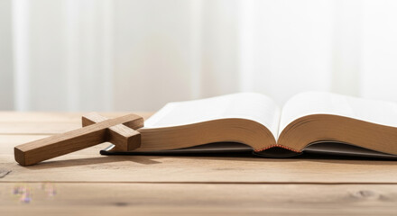 Open Bible with wooden cross on wooden table in soft light  