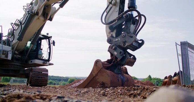Excavator operator retooling machine by attaching bucket after breaker work
