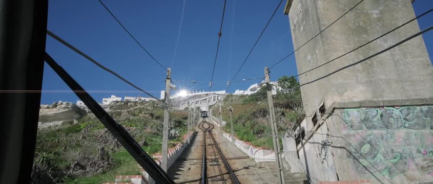 Historic Ascensor da Nazar&eacute; funicular as it travels up the steep hill, connecting the lower beach area with the S&iacute;tio district. Captured on a bright, sunny day
