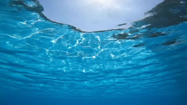 Underwater sunlit ocean surface with shimmering light patterns