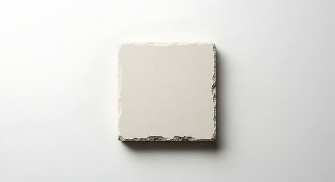 A close up view of a rough hewn rectangular stone or brick with a light gray color
