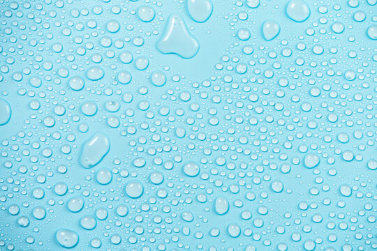 Close plan of the round drop of water on blue background. Crystal transparency.