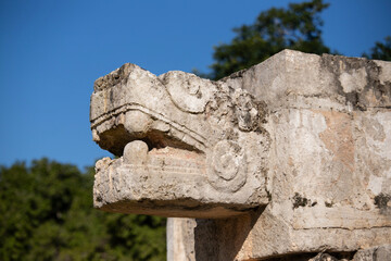 Obraz premium Detailed views of the historic Platform of Venurs Tstands majestically against a vibrant blue sky, showcasing its ancient Mayan architecture at Chichen Itza in Mexico.
