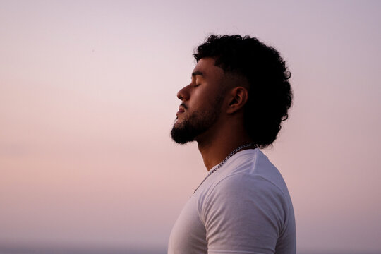 Young man meditating, finding calm and relaxation