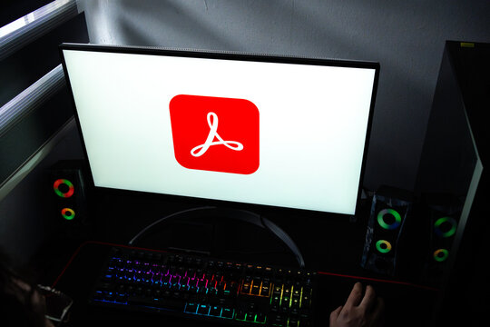Punta Arenas, Chile &ndash; February 17, 2026: A person working at a desk with the Adobe Acrobat logo displayed on a computer monitor